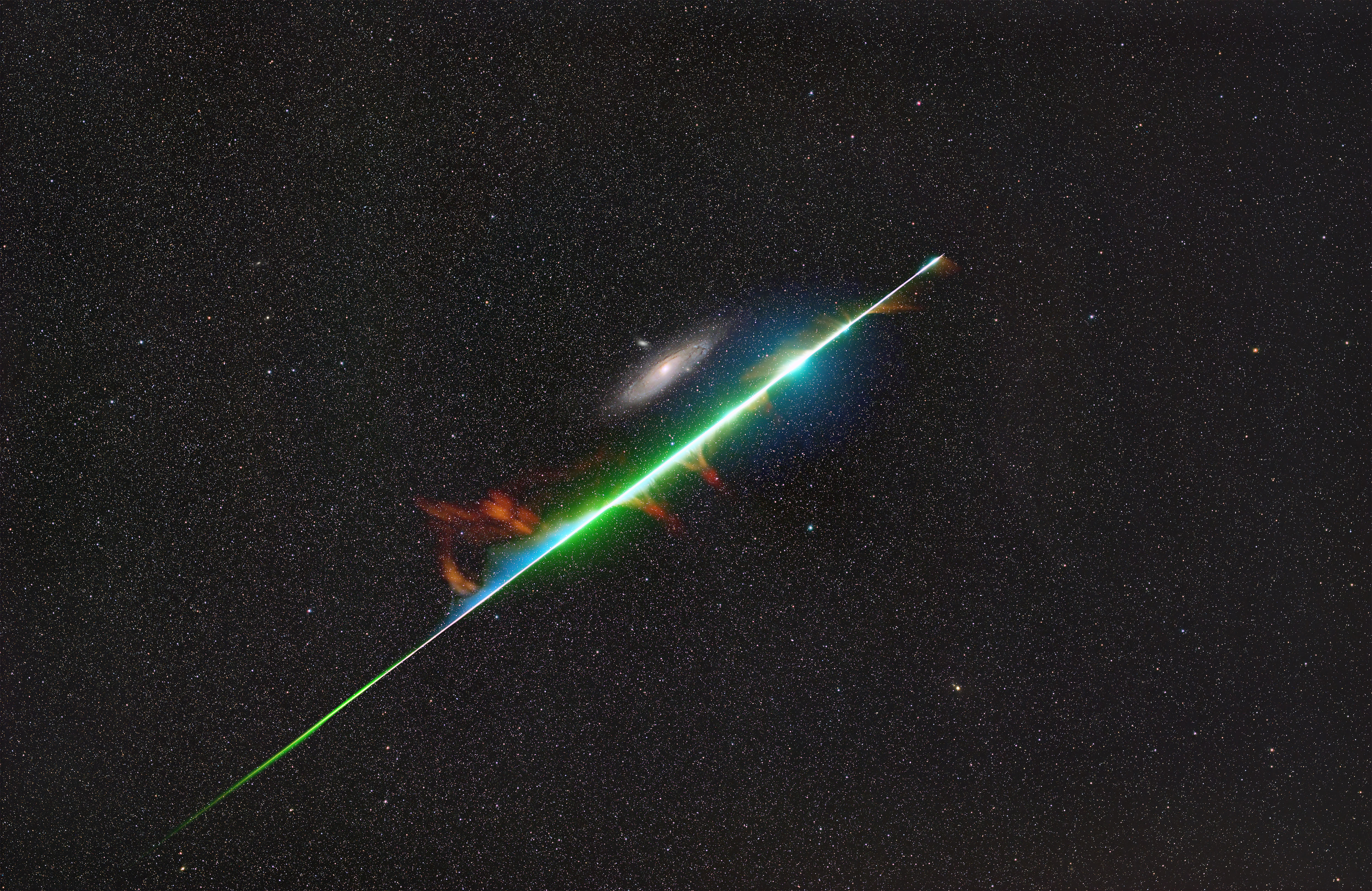a bright meteor cut a fiery straight line across the sky. Andromeda clearly visible behind it.